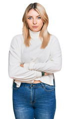 Young caucasian woman wearing casual winter sweater skeptic and nervous, disapproving expression on face with crossed arms. negative person.