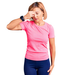Fototapeta premium Young blonde woman wearing sportswear tired rubbing nose and eyes feeling fatigue and headache. stress and frustration concept.