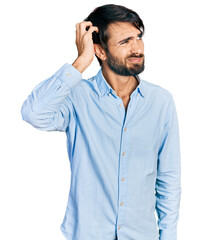 Fototapeta premium Hispanic man with blue eyes wearing business shirt confuse and wondering about question. uncertain with doubt, thinking with hand on head. pensive concept.