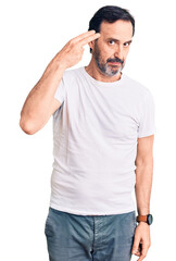 Fototapeta premium Middle age handsome man wearing casual t-shirt shooting and killing oneself pointing hand and fingers to head like gun, suicide gesture.