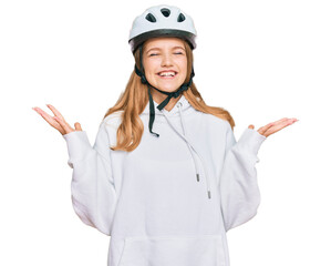 Beautiful young caucasian girl wearing bike helmet celebrating mad and crazy for success with arms raised and closed eyes screaming excited. winner concept