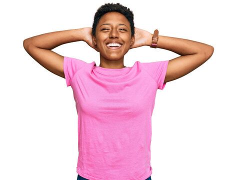 Young african american woman wearing casual clothes relaxing and stretching, arms and hands behind head and neck smiling happy