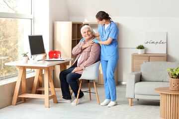 Happy senior man with nurse at home