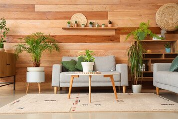 Interior of living room with green plants, sofa and table