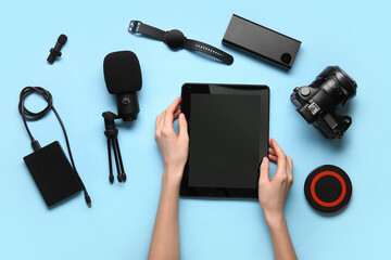 Female hands with different gadgets on color background