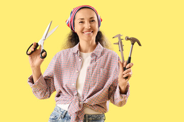 Female shoemaker with tools on yellow background
