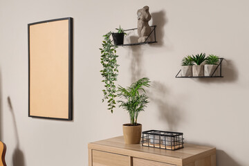 Shelves with green plants and statuette on light wall in living room