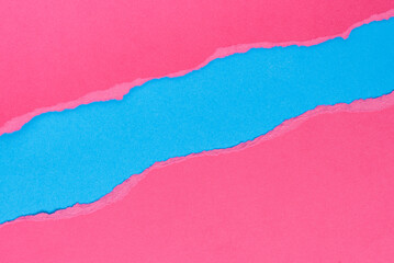 Torn pink paper on blue background. Space for text.