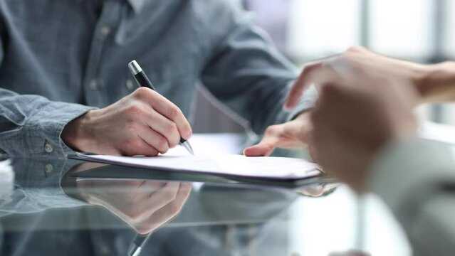 Close-up discussion of documents at the desk in the office