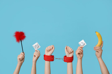 Female hands with sex toys, condoms and banana on color background