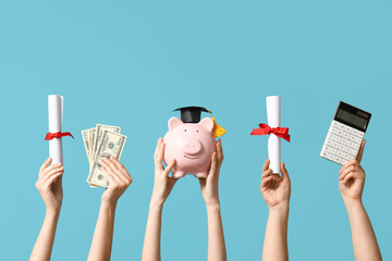 Female hands holding diplomas, money, calculator and piggy bank with decorative graduation hat on...