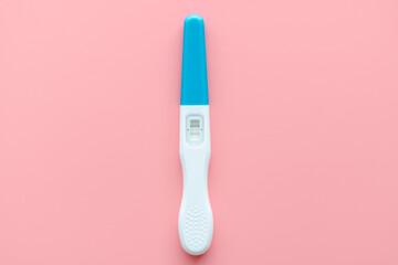 A white pregnancy test is isolated on a pink background. Women's health, fertility, planning maternity and pregnancy concept. Stack of test kits with positive results. Copy space for advertising.