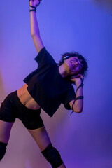 A woman is dancing and wearing headphones. She is smiling and she is enjoying herself. young woman...