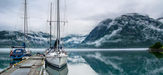 Serene mountain lake with docked sailboats