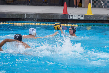 High School water polo player shooting the ball.