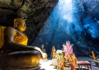 Serene buddha statue in sunlit cave