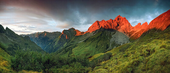 Majestic sunrise casting a warm glow on rugged mountain peaks and lush valleys