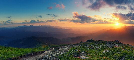 Breathtaking panoramic view of a sunrise over serene mountain ranges with vibrant skies