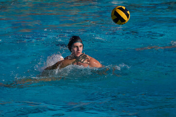 High School water polo player shooting the ball.