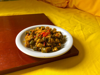 Delicious cooked okra with tomato sauce served on a porcelain plate