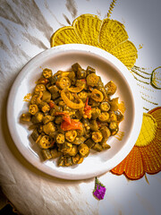 Delicious cooked okra with tomato sauce served on a porcelain plate