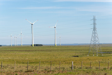 A field with a tall power tower in the background