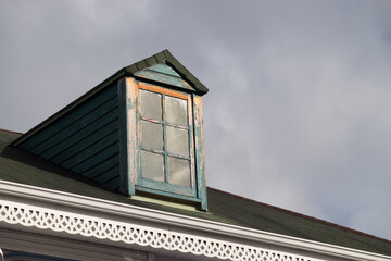 A house with a blue roof and a window on the roof