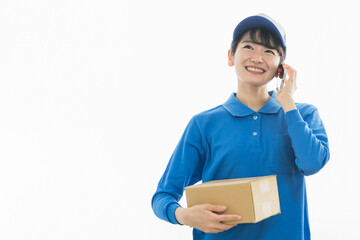 スマホで通話する配達員の女性（配達・軽貨物ドライバー・宅配・配達員・宅急便）
