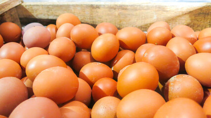 bunch of fresh brown chicken eggs in wooden crate ready to sell in the grocery market
