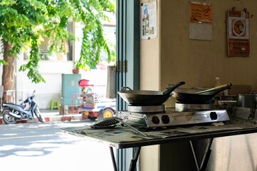 Interior of Thong Heng Lee, a family-run street food restaurant near the Grand Palace selling traditional Thai dishes, with an open kitchen facing a tree-lined street - Bangkok, Thailand