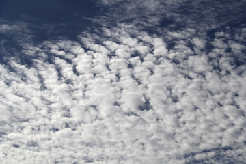 Blue sky with white clouds forming a mackerel sky pattern textured abstract background