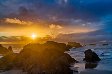 Dramatic coastal sunset with rocks and waves