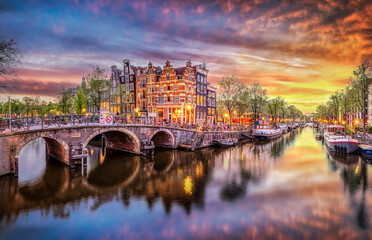 Sunset over amsterdam canal with historic architecture