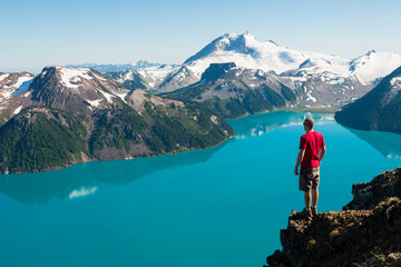 Man overlooking turquoise mountain lake