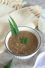 Mung Bean Porridge or Bubur Kacang Hijau, Indonesian dessert porridge of mung beans with coconut milk, pandan leaf and ginger. Served in white bowl.