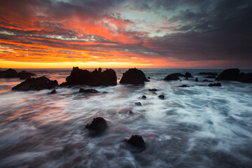 Dramatic sunset over rocky seascape