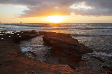 Ocean sunset view from rocky shoreline