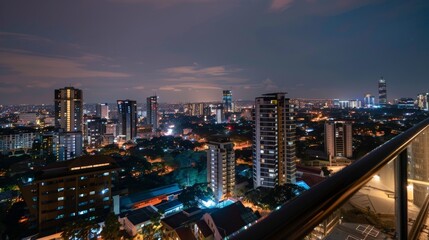 A view of the apartment from the balcony. The balcony overlooks a city skyline. The city skyline is lit up at night, and it is a beautiful sight.