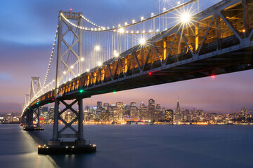 Twilight cityscape with illuminated bridge