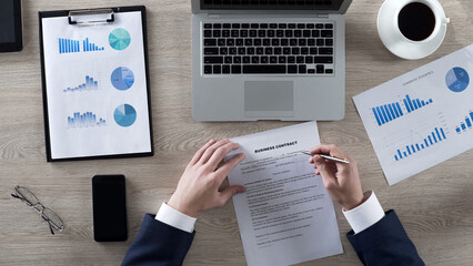 Businessman signing contract at desk