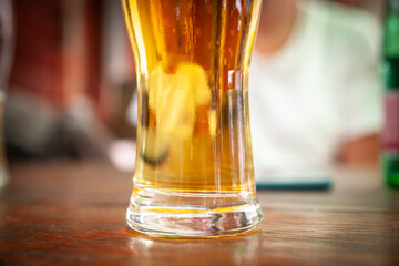 Selective blur on a Closeup on a beer mug containing a light beer, pilsner / lager style, served in a standard pint size glass.