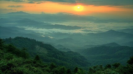 A serene sunrise view over a misty mountainous landscape, showcasing layers of mountains and a vibrant sky with scattered clouds
