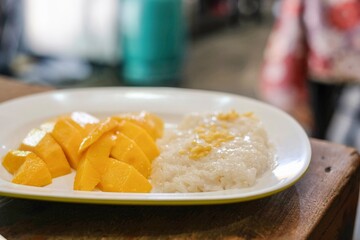 Mango with sticky rice and coconut milk at Thong Heng Lee, a family-run street food restaurant selling traditional Thai dishes in Phra Nakhon, near the Grand Palace - Bangkok, Thailand