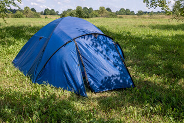 Traveler Blue Tent On Green Grass In Summer Sunlight