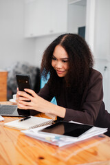 Businesswoman is attentively using her smartphone in the office, seamlessly integrating mobile technology into her workday.