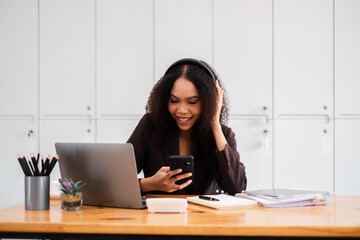 Smiling businesswoman in the office receives pleasing news on her smartphone, adding a touch of joy to her workday.