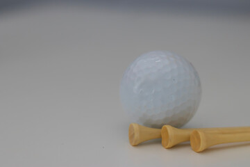 three golf balls with golf tees on a white background, golf, golfing, summer sport, summer time