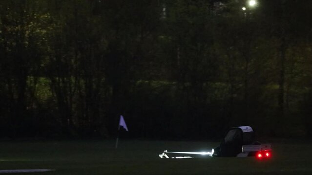 Stockholm, Sweden A cart picks up golf balls on a driving range at night.