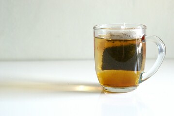 A cup of tea with tea bag on white background with copy space area, hot drink for breakfast