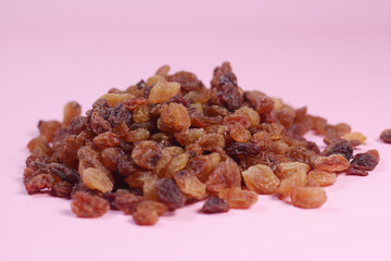  brown raisin on pink background, close up,